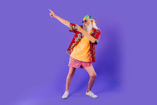 Senior man with eccentric look  - 60 years old man having fun, portrait on colored background, concepts about youthful senior people and lifestyle - Photo, Image