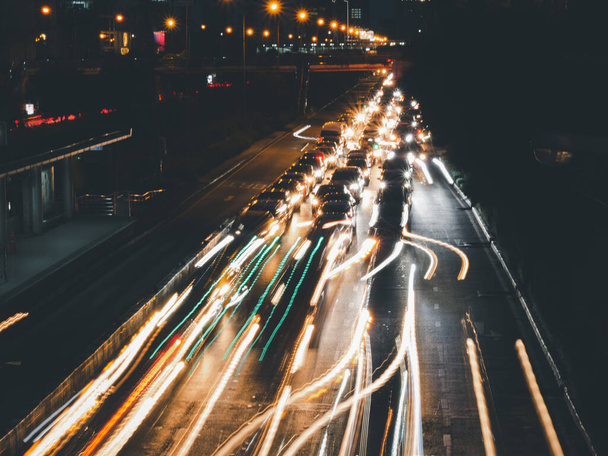 Długa ekspozycja szlaki świetlne na ulicy w nocy, prędkość ruchu światła z rozmytymi śladami z samochodów na drodze  - Zdjęcie, obraz