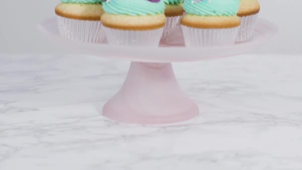 Lépésről lépésre. Rendezni sellő vanília cupcakes csokoládé sellő farok egy cupcake stand. - Felvétel, videó