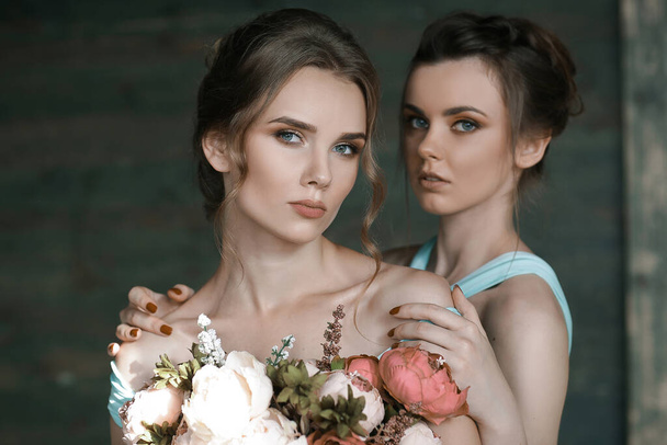 Close up portrait of two pretty woman bestfriends with beautiful hairstyle holding flowers. Beauty portrait of sensual woman with flowers. Cosmetology. - Φωτογραφία, εικόνα