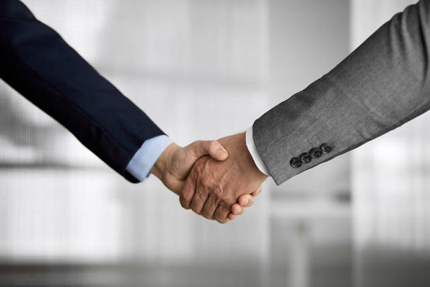 Business people in office suits standing and shaking hands, close-up. Business communication concept. Handshake and marketing - Zdjęcie, obraz