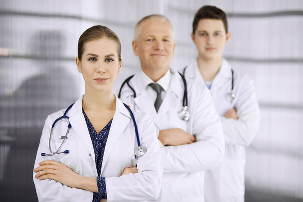 Doctors standing as a team with arms crossed in clinic and ready to help patients. Medical help, insurance in health care, best disease treatment and medicine concept - Fotografie, Obrázek