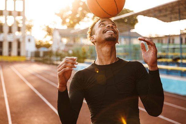 Photo of african cheerful happy strong young sports man at stadium outdoors play basketball. - Φωτογραφία, εικόνα