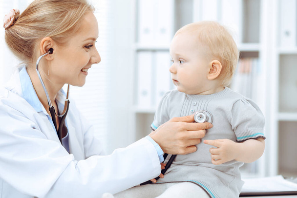 Doctor and patient in hospital. Little girl is being examined by doctor with stethoscope. Medicine concept - Фото, зображення