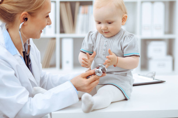 Doctor and patient in hospital. Little girl is being examined by doctor with stethoscope. Medicine concept - Foto, Imagem