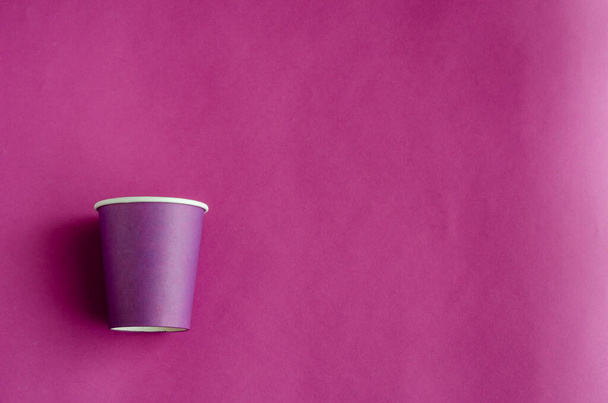 Környezetbarát eldobható evőeszközök utcai italokhoz. Egyetlen orgona papír csésze kávé lila alapon. Másold a helyet. Szelektív fókusz. - Fotó, kép
