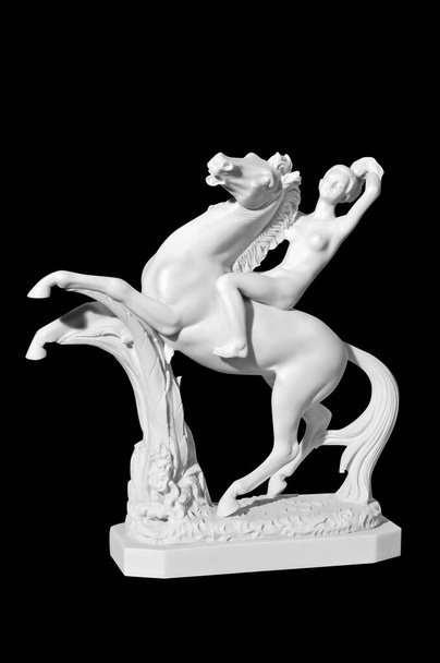 Estatua de mármol clásico de una niña en un caballo sobre un fondo negro
 - Foto, imagen