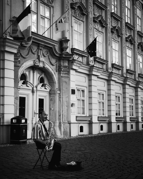 Черно-белая фотография человека, играющего на саксофоне на улице. Тимисоара, Румыния - 5 июня 2020 года - Фото, изображение