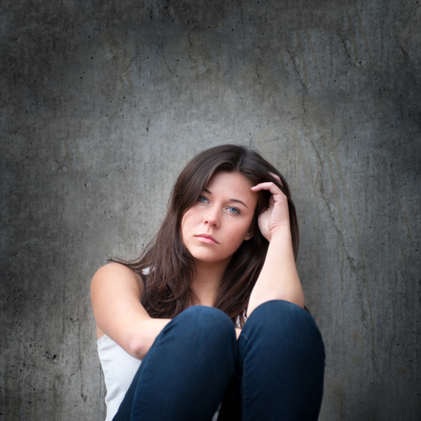 Odkryty portret smutnej nastolatki wyglądającej troskliwie o problemach przed brudną szarą ścianą - Zdjęcie, obraz