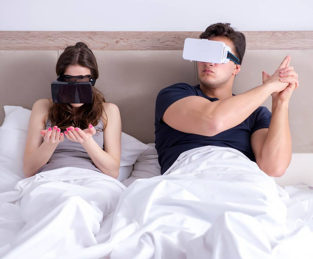 Дружина і чоловік з окулярами віртуальної реальності в ліжку
 - Фото, зображення