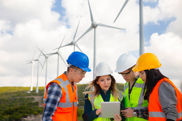 Young engineers and workers having a meeting at wind farm - Photo, Image