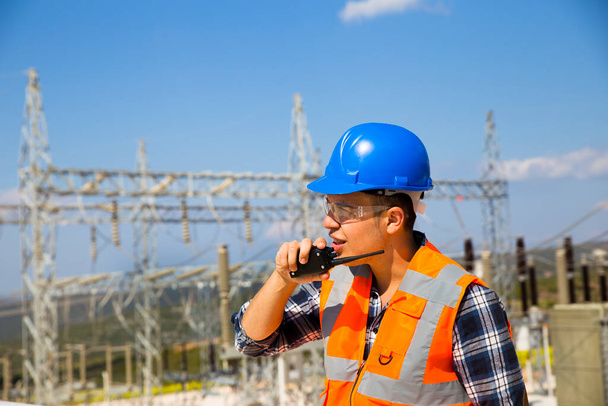 Empresario usando walkie-talkie contra planta de energía - Foto, imagen