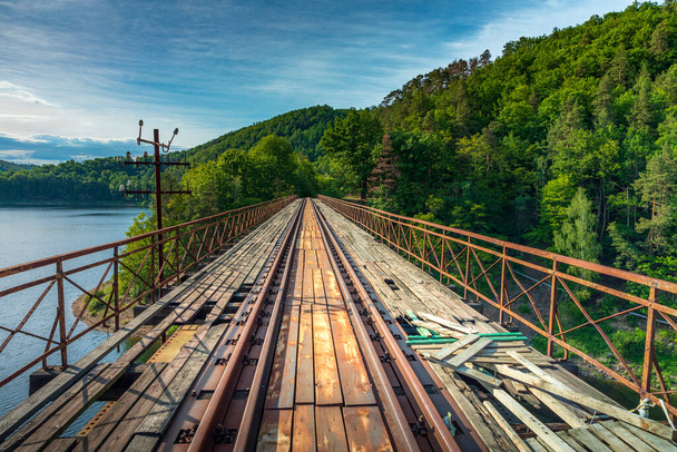 Historický ocelový příkrov podpíral zavěšený železniční most z roku 1902 přes řeku Bobr v polských Pilchowicích v překrásném ránu. Bývalá německá inženýrská stavba na uzavřené železniční trati - Fotografie, Obrázek