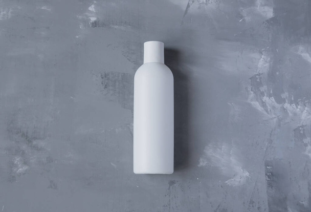 bouteille blanche propre sans perles sur un fond gris - Photo, image