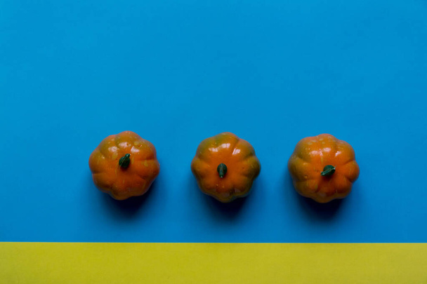 small pumpkins on a bright colored background - Zdjęcie, obraz