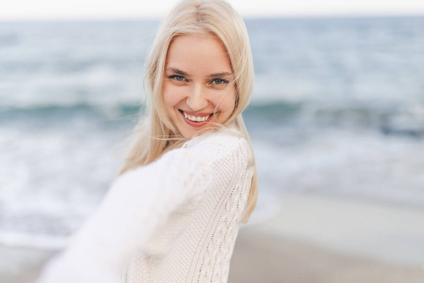 Pretty woman smiling near ocean - Фото, изображение