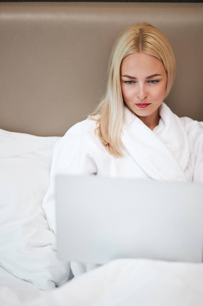 beautiful woman in bathrobe lying on bed - Фото, зображення