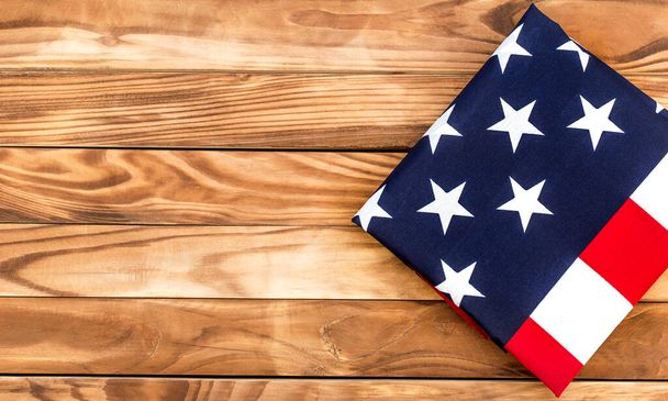 Gefaltete amerikanische Flagge auf Holzgrund. Raum für Text. Ansicht von oben. - Foto, Bild