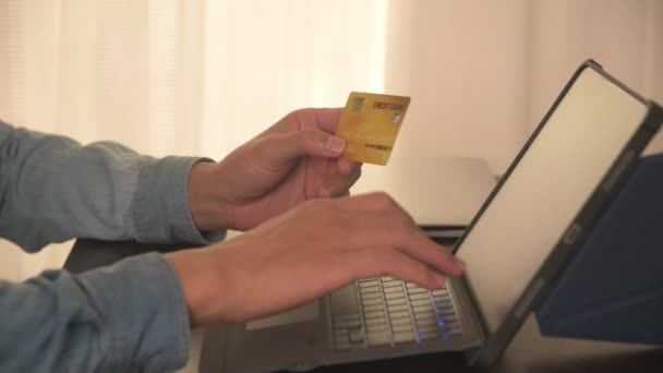 Mann tippt Kreditkartennummer ein, um mit Kreditkarte auf Tablet im Home Office einkaufen, Banking, Home und Lifestyle-Konzept zu bezahlen - Filmmaterial, Video