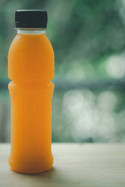 Pure orange juice in bottle for good healthy on wooden table - Photo, Image