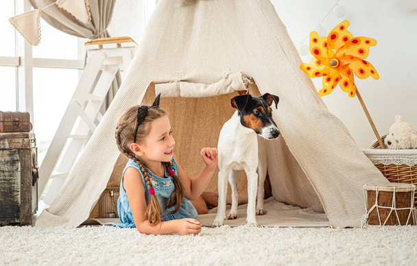 Little girl in wigwam with fox terrier - Photo, Image