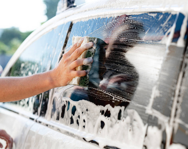 Hand with sponge washing car window - Fotó, kép
