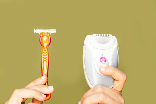 partaveitsi tai parranajokone ja epilaattori naisen kädessä. Sähköinen vs manuaalinen parranajo - Valokuva, kuva