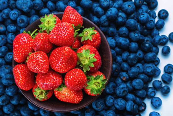 Blaubeeren und Erdbeeren Hintergrund. Ansicht von oben. - Foto, Bild
