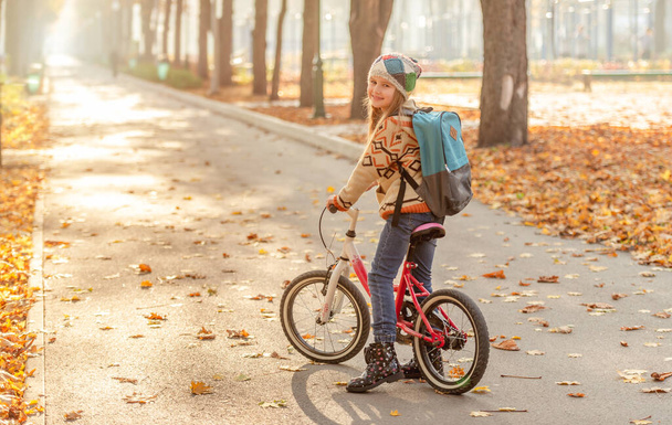 Happy girl riding bike in park - Photo, image