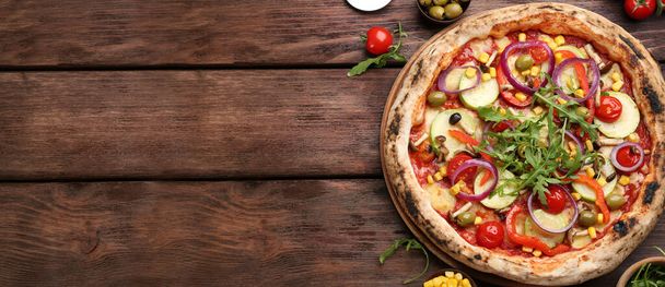 Top view of hot delicious pizza on wooden table, space for text. Banner design  - Foto, Bild