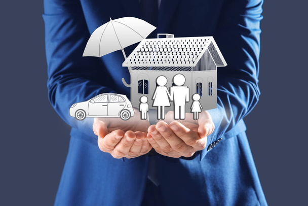 Insurance concept - umbrella demonstrating protection. Man with illustrations on dark background, closeup - Photo, image