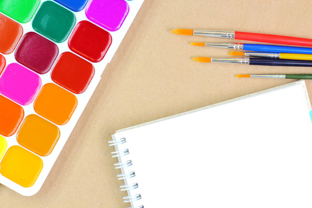 Watercolor paints, brushes, sketchbook on a white background. School or education theme concept. Top view, flat lay, place for text, copy space. - Zdjęcie, obraz