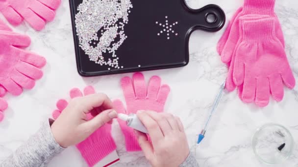 Plat gelegd. Rhinestone roze kids handschoenen met sneeuwvlok vormen. - Video