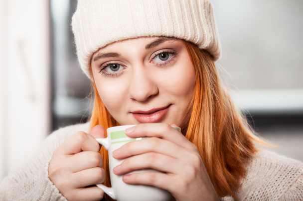Woman wearing winter clothing drinking hot coffee - Фото, зображення