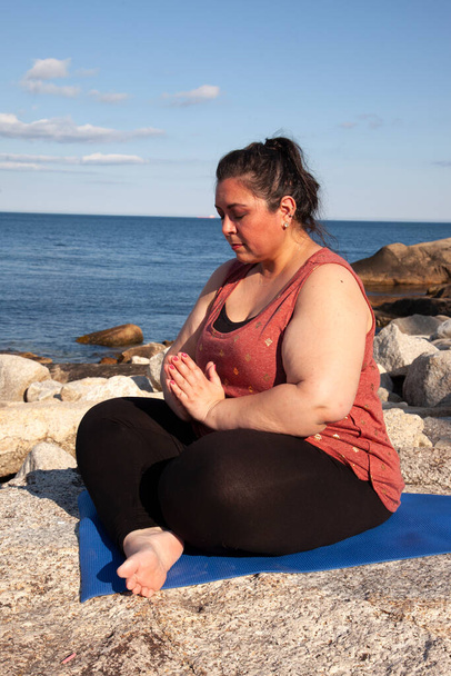 femme consciente au bord de la mer avec les mains pliées dans la pose de prière  - Photo, image