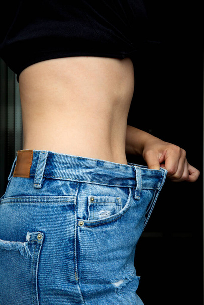 Slim female body in big jeans. Diet concept - Φωτογραφία, εικόνα