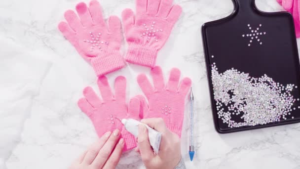 Leżeć płasko. Rhinestone różowe rękawiczki dla dzieci z kształtami płatków śniegu. - Materiał filmowy, wideo
