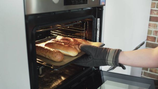 Baker saca pan caliente del horno. - Foto, Imagen