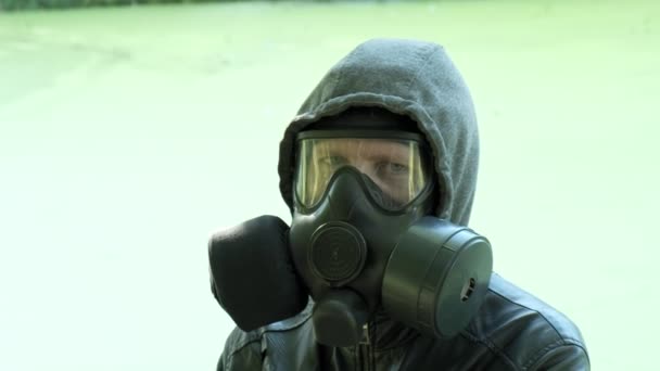 Mies kaasunaamarissa lähellä myrkyllistä säiliötä. kemiallinen aseidensuojelu, virusepidemia - Materiaali, video