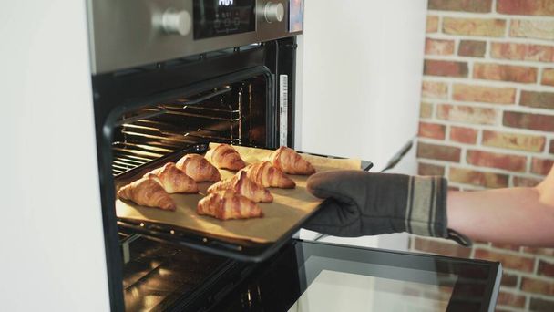 Kook het nemen van gekookte croissants - Foto, afbeelding