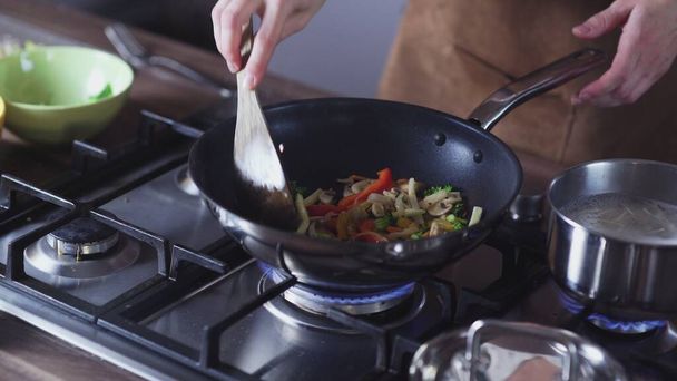 Kobieta smaży warzywa na patelni wok w domu - Zdjęcie, obraz