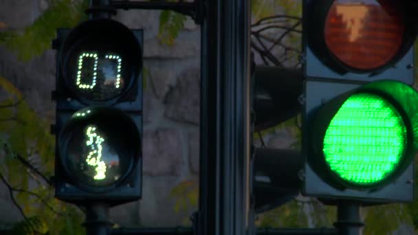 Feu de circulation qui indique un compte à rebours avec chiffres et un homme courant comme symbole pour les piétons et un feu vert qui change - Séquence, vidéo