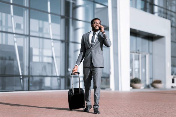 Щасливий африканський бізнесмен Чат на телефоні прибуває в аеропорт, повна довжина
 - Фото, зображення