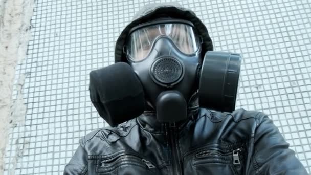 Człowiek w masce przeciwgazowej na epidemii stojący na zewnątrz. broń chemiczna, ochrona przed wirusami - Materiał filmowy, wideo