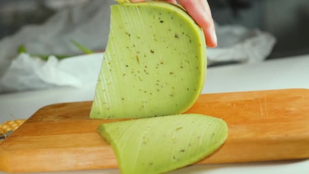 close-up op vrouw snijden groene kaas met kruiden en specerijen. - Video