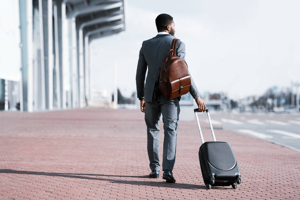 Бизнесмен собирается в деловую поездку Прибытие в аэропорт, вид сзади - Фото, изображение