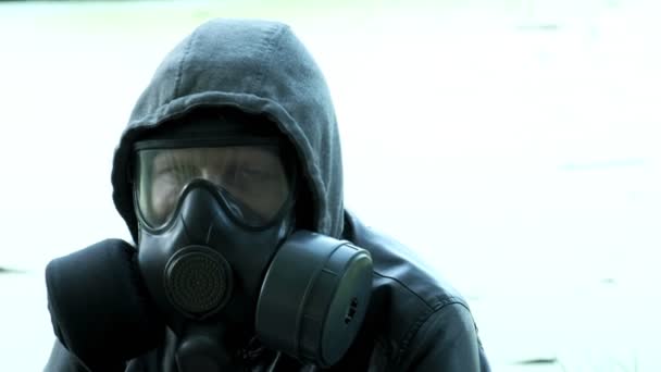 uomo in maschera antigas vicino serbatoio tossico. protezione delle armi chimiche, epidemia di virus - Filmati, video