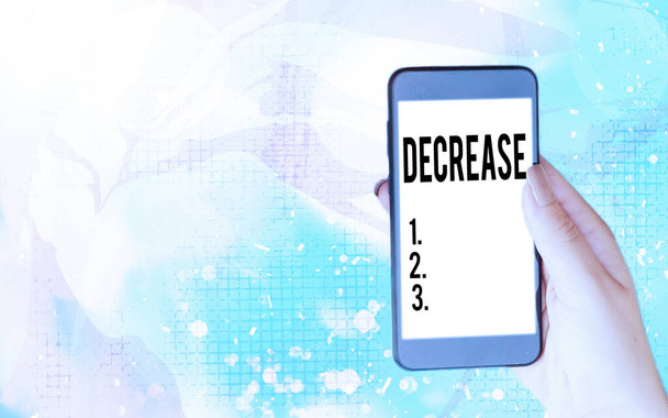 Word writing text Decrease. Business concept for the process of growing progressively less in size, amount, etc. Modern gadgets with white display screen under colorful bokeh background. - Photo, Image