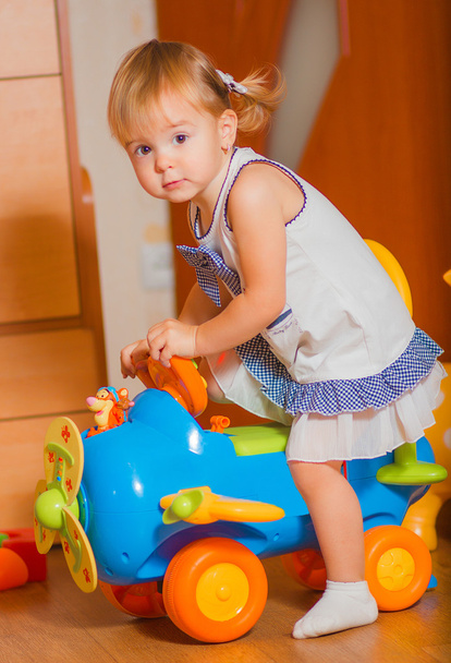 a little girl goes on a toy car - Fotografie, Obrázek