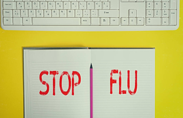 Handschriftlicher Text Stop Grippe. Konzept bedeutet, der Virusinfektion der Lungen und Atemwege ein Ende zu setzen Kopierraum auf Notizbuch über gelbem Hintergrund mit Tastatur auf dem Tisch. - Foto, Bild